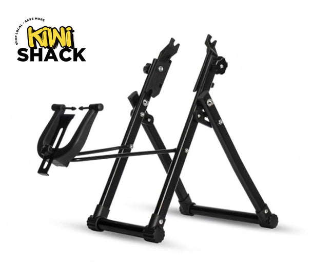 A black foldable bicycle repair and maintenance stand with a frame holder cradle on the front against a white background, featuring the "Kiwi Shack" logo in the upper left corner.