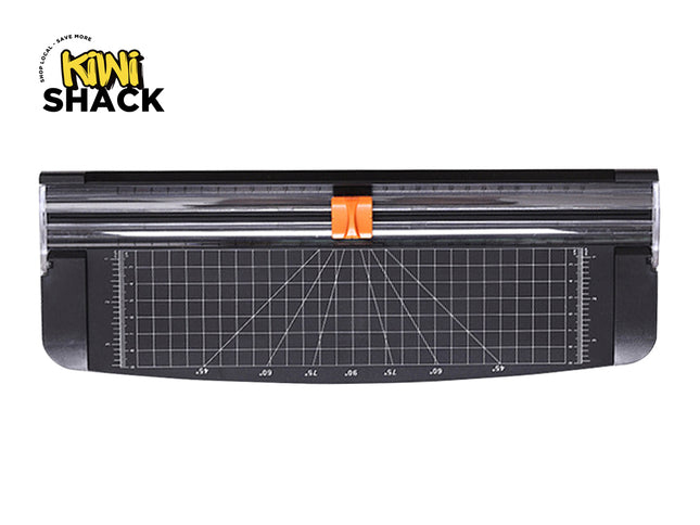 A black rotary paper trimmer featuring a grid-lined base with angle measurement guides and an orange cutting blade handle against a white background, featuring the "Kiwi Shack" logo in the upper left corner.