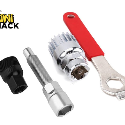 A bicycle repair and maintenance tool set laid out against a white background, including a black crank puller, a silver bottom bracket remover, a crank arm removal tool, and a wrench with a red handle, featuring the "Kiwi Shack" logo in the upper left corner.
