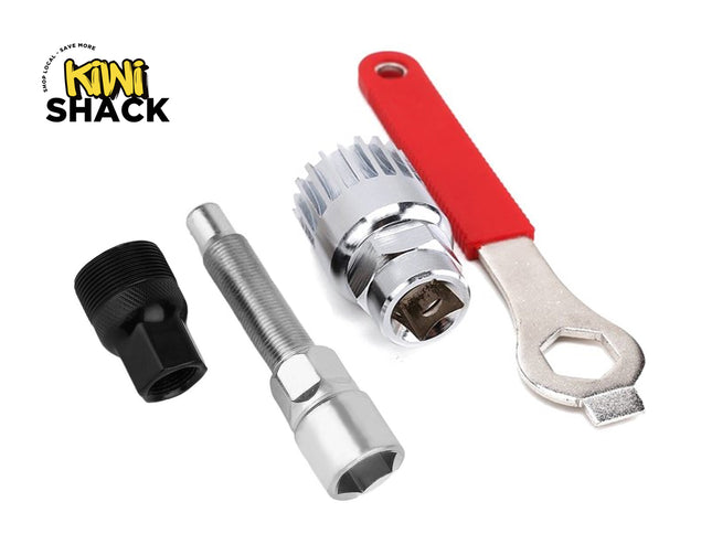 A bicycle repair and maintenance tool set laid out against a white background, including a black crank puller, a silver bottom bracket remover, a crank arm removal tool, and a wrench with a red handle, featuring the "Kiwi Shack" logo in the upper left corner.