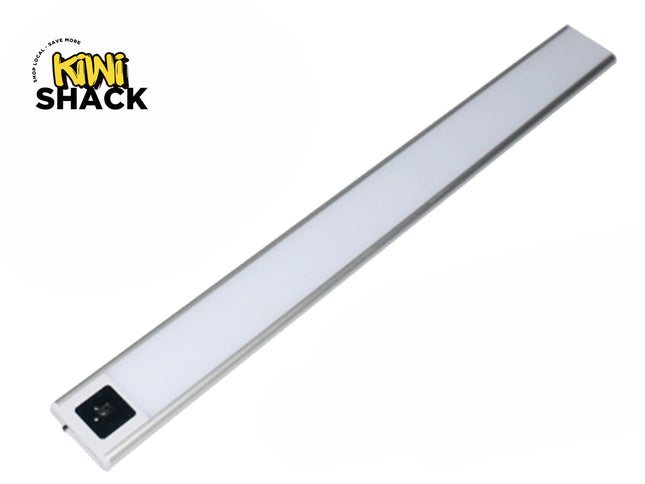 A slim, silver-rimmed LED under-cabinet light bar with a frosted diffuser panel and a motion sensor control module on one end against a white background, featuring the "Kiwi Shack" logo in the upper left corner.