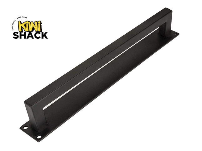 A matte black sliding barn door pull handle with a rectangular backplate and pre-drilled screw holes against a white background. A "Kiwi Shack" logo appears in the top-left corner.