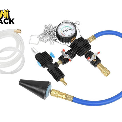 A cooling system pressure tester and vacuum purge refill kit featuring a circular pressure gauge, black manifold blocks with control valves, a blue hose with a conical rubber adapter, and a clear transparent fluid hose with brass fittings, with a "Kiwi Shack" logo in the top left corner.
