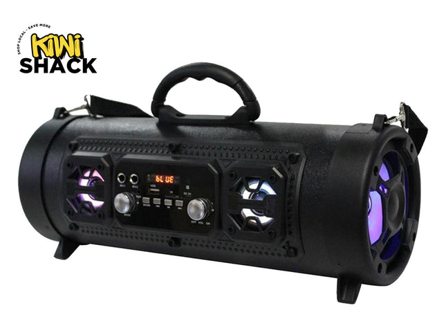 A portable black Bluetooth cylinder speaker with LED accent lights, control knobs, a digital display, and a carrying handle, featuring the "Kiwi Shack" logo in the top-left corner.