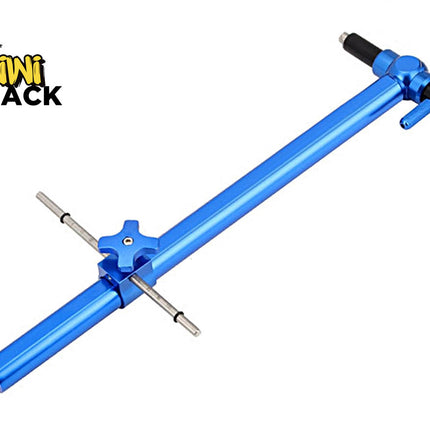 A blue anodized aluminum bicycle chainstay tensioner tool with silver metal pins and black adjustment knobs, shown on a plain white background with the Kiwi Shack logo in the top-left corner.