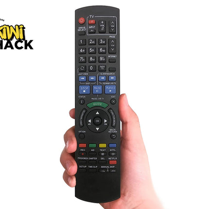 Hand holding a black remote control with visible buttons, against a white background with 'Kiwi Shack' branding.