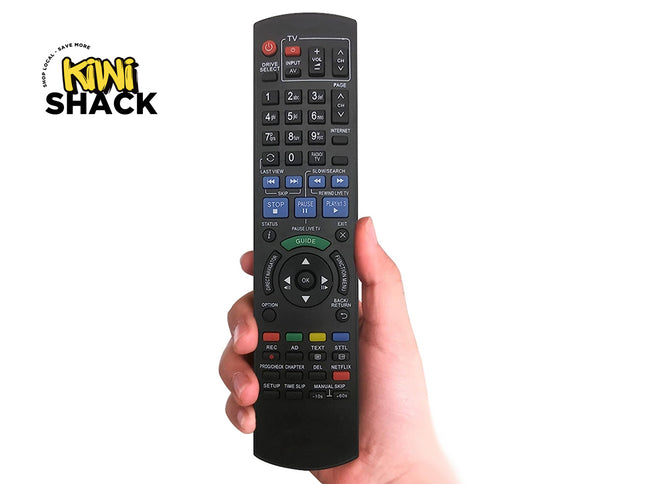 Hand holding a black remote control with visible buttons, against a white background with 'Kiwi Shack' branding.