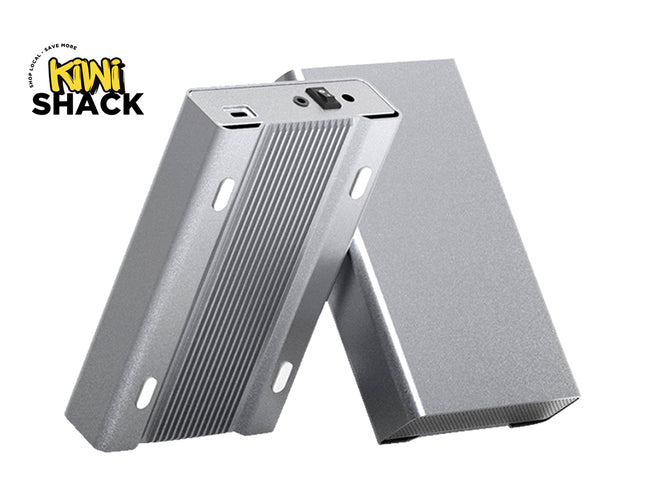 Silver anodized extruded aluminum rectangular heatsink / electronic enclosure housings showing slotted mounting flanges, grooved side/face fins, an end-cap interface panel with a power switch and jack port, a second matching enclosure body leaned behind it, and the Kiwi Shack logo watermark.