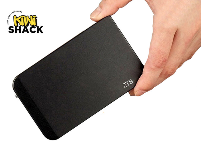 A sleek, black 2TB portable external hard drive held by a hand against a white background, featuring the "Kiwi Shack" logo in the upper left corner.