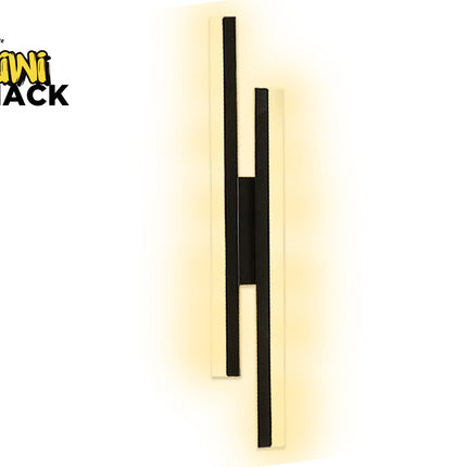 A modern wall-mounted light fixture with two vertical black bars and a central black connector, set against a warm yellow glow. The brand logo 'Kini Shack' is visible in the top-left corner.