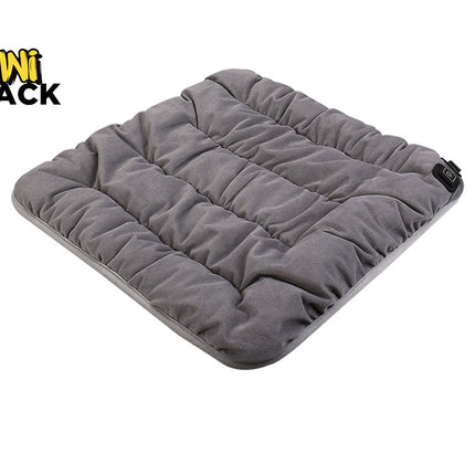 A square grey quilted heated pet pad featuring horizontal channel stitching and a power control button on the side against a white background, featuring the "Kiwi Shack" logo in the upper left corner.