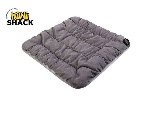 A square grey quilted heated pet pad featuring horizontal channel stitching and a power control button on the side against a white background, featuring the "Kiwi Shack" logo in the upper left corner.