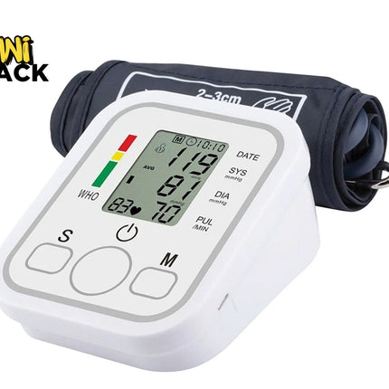 A digital upper arm blood pressure monitor with a white base unit displaying readings on an LCD screen and a rolled-up dark blue cuff behind it against a white background, featuring the "Kiwi Shack" logo in the upper left corner.
