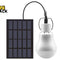 A portable solar-powered LED bulb connected by a black cord to a rectangular solar panel against a white background, featuring the "Kiwi Shack" logo in the upper left corner.