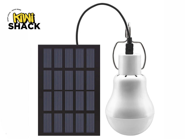 A portable solar-powered LED bulb connected by a black cord to a rectangular solar panel against a white background, featuring the "Kiwi Shack" logo in the upper left corner.