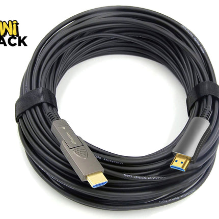 A coiled black HDMI cable with USB-C connectors on both ends, secured with a black elastic band, shown on a white background with the KINI SHACK logo in the top-left corner.