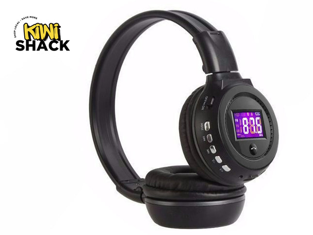 A pair of black over-ear wireless headphones featuring a digital LCD screen and playback control buttons on the ear cup, with the "Kiwi Shack" logo in the top-left corner.