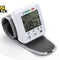 Wrist blood pressure monitor with digital display on a white background, branded 'Kiwi Shack'.