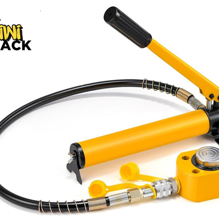 Yellow hydraulic hand pump connected via a spring-guarded black high-pressure hose to a compact yellow hydraulic cylinder jack with a silver piston cap, yellow protective dust caps, and Kiwi Shack logo in top left.