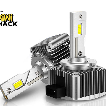 Two automotive LED headlight bulbs with silver heat sinks and yellow LED chips, shown on a white background with the Kiwi Shack logo in the top left.