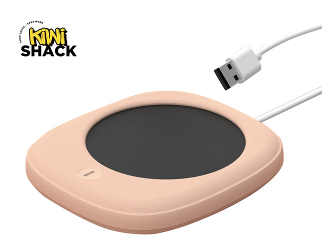 A peach-colored wireless charging pad with a dark gray circular center, shown with a white USB cable on a white background. The Kiwi Shack logo is visible in the top-left corner.