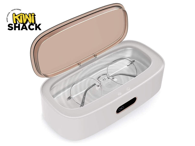 A white and rose gold portable UV glasses cleaner with its lid open, showing a pair of round-frame glasses inside. The KINI SHACK logo is visible in the top-left corner.