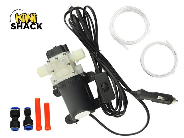 A 12V portable electric mini diaphragm water pump kit with power cord, cigarette lighter plug, tubes, and connectors, featuring the "Kiwi Shack" logo in the top-left corner.