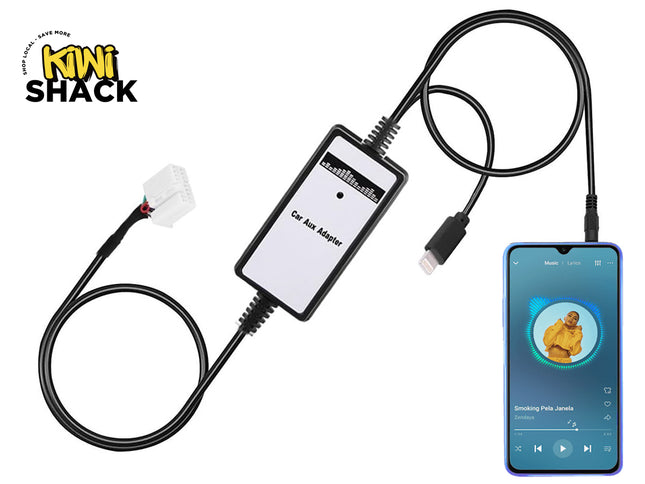 A black car aux adapter module labeled "Car Aux Adapter" connected via cables to a white vehicle wiring harness on one end and a smartphone playing music on the other, set against a plain background with the "Kiwi Shack" logo in the top left corner.