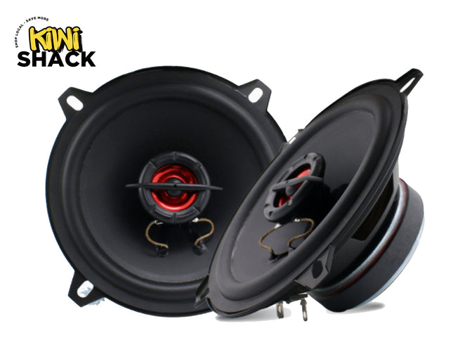 Two black car audio speakers shown on a white background, with one speaker face turned toward the viewer and the other angled to show the side and internal structure. The Kiwi Shack logo is visible in the top-left corner.