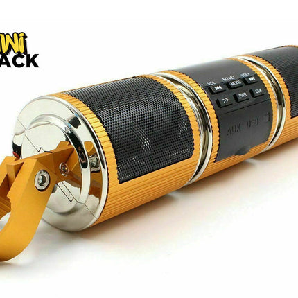 A portable cylindrical speaker by Mini Shack, featuring a black mesh grille, gold-colored textured plastic, and a shiny gold carrying loop, shown on a white background with the Mini Shack logo in the top-left corner.