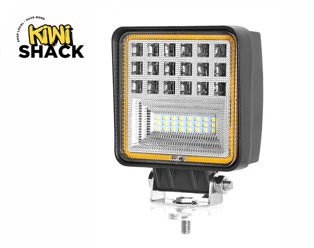 A square LED work light with multiple spotlight lenses and an LED strip section, mounted on an adjustable metal bracket against a white background, with the "Kiwi Shack" logo in the upper left corner.