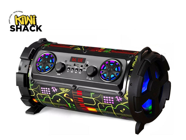 A cylindrical portable Bluetooth speaker with a black body, colorful graffiti-style graphics in green, yellow, and red, and illuminated blue LED accents on the speaker grilles and rear fans. The Kiwi Shack logo is visible in the top-left corner.