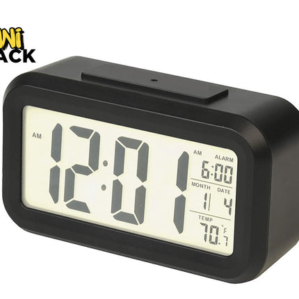 A modern black digital alarm clock with a backlit LCD screen showing time, alarm setting, calendar date, and temperature, featuring the "Kiwi Shack" logo in the top-left corner.