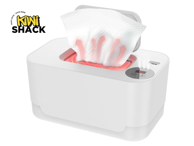 A white electronic baby wipe warmer box with an open lid, showing a tissue being heated with graphic heat waves and a digital temperature display on top, set against a white background with the "Kiwi Shack" logo in the top left corner.