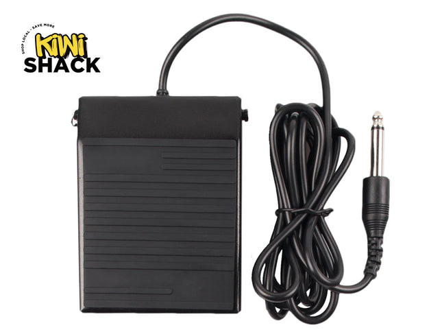 Concise Alt Text (Screen Readers)
Black rectangular foot pedal with horizontal ribbed surface texture, connected via a coiled/looped black cable to a 6.35mm 1/4-inch mono audio jack plug, featuring the Kiwi Shack logo in the top left.