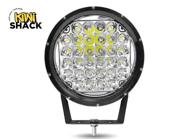 A round black LED off-road light with a mounting bracket, shown on a white background with a Kiwi Shack logo in the top-left corner.