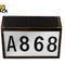 Dark-rimmed rectangular solar-powered LED house number / address plate featuring a dark bronze-finish or wood-grain frame, a black photovoltaic solar panel on top, a white illuminated front panel displaying large black characters "A868", and the Kiwi Shack logo watermark.