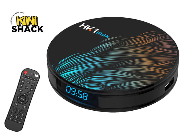 A black Kiwi Shack HX1max streaming box with a colorful blue, teal, and orange wave pattern on top, shown next to its remote control on a white background.