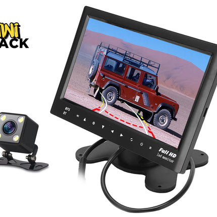 A backup camera system consisting of a small cube-shaped camera with built-in lights and a Full HD LED monitor displaying a rear-view parking feed of a red off-road vehicle against a white background, with the "Kiwi Shack" logo in the upper left corner.