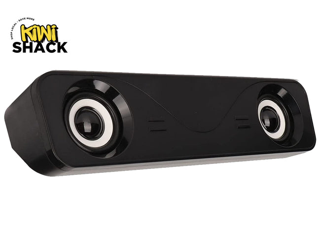 A sleek black rectangular computer soundbar with two exposed speakers featuring white trim rings, set against a white background. A "Kiwi Shack" logo appears in the top-left corner.