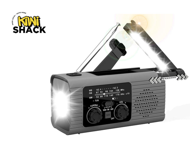 A gray Kiwi Shack emergency radio with a folding solar panel on top, a telescoping antenna, and bright light effects on the front and side, shown on a white background with the Kiwi Shack logo in the top left.