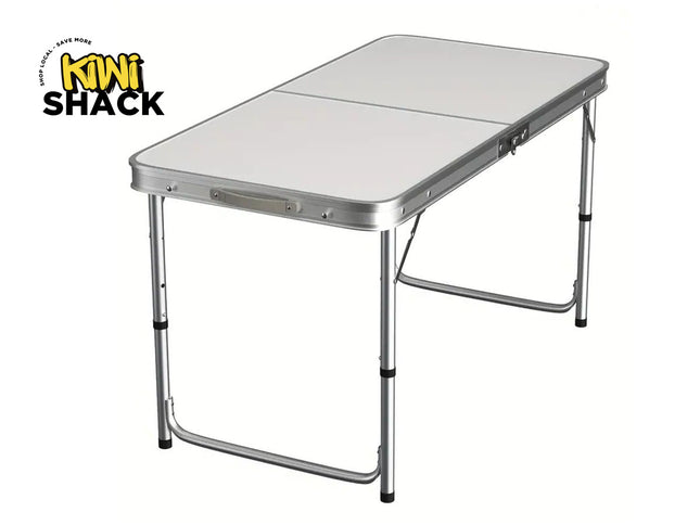 Foldable camping table with metallic finish on a white background, featuring the Kiwi Shack logo.