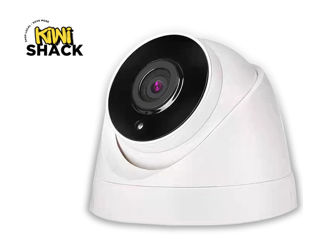 White security camera with black lens on a white background, featuring the Kini Shack logo.