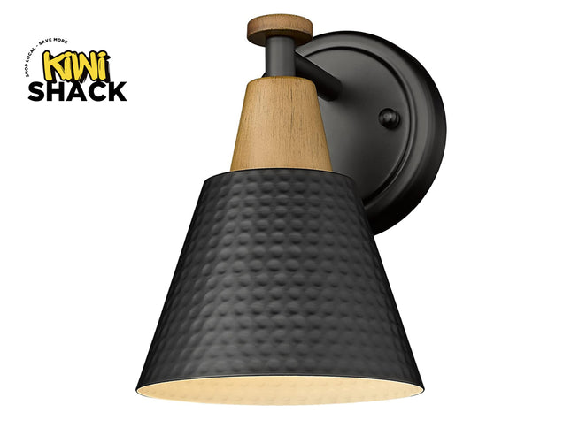 Modern farmhouse-style black and wood accent wall sconce with a hammered metal shade, round backplate, and Kiwi Shack logo watermark.