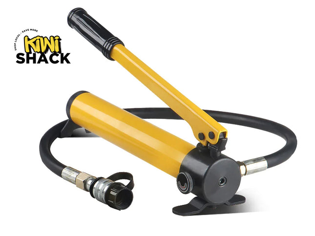 Yellow hydraulic hand pump with a black handle grip, pressure relief valve dial, attached high-pressure black hose with quick-disconnect coupler, metal base plate, and Kiwi Shack logo in top left.
