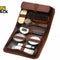 Brown zippered travel shoe shine kit case laid open, containing elastic-strapped wooden shoe shine brushes with horsehair/synthetic bristles, small dauber brushes, a shoe polish applicator brush with white bristles and black handle, two round tin polish containers, a small cloth/buffer, and the Kiwi Shack logo watermark.