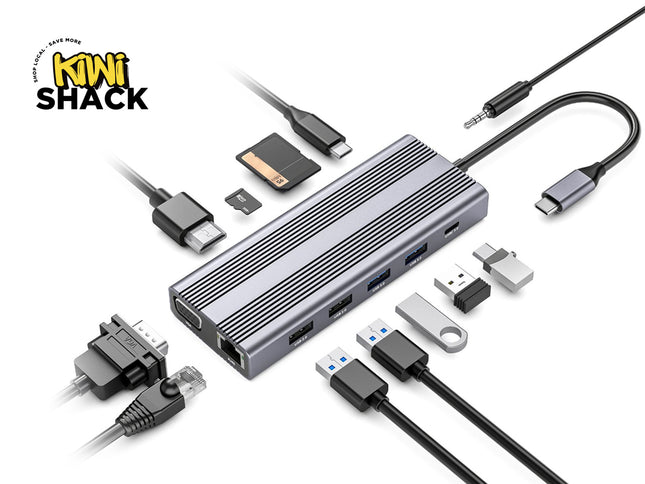 A silver aluminum USB-C hub with multiple ports and several attached and displayed accessories including cables, a USB drive, a SD card, and a keychain tool, on a white background with the Kiwi Shack logo.