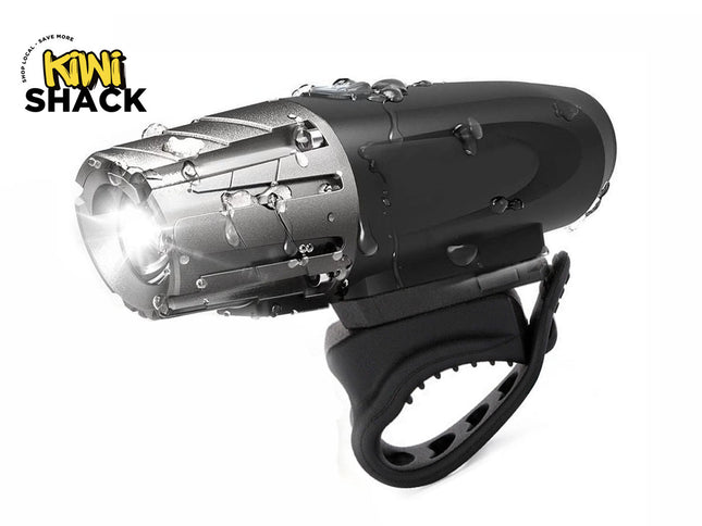 A black and silver waterproof bicycle headlight with a bright illuminated front beam, shown on a white background with a 'Kini Shack' logo in the top-left corner.