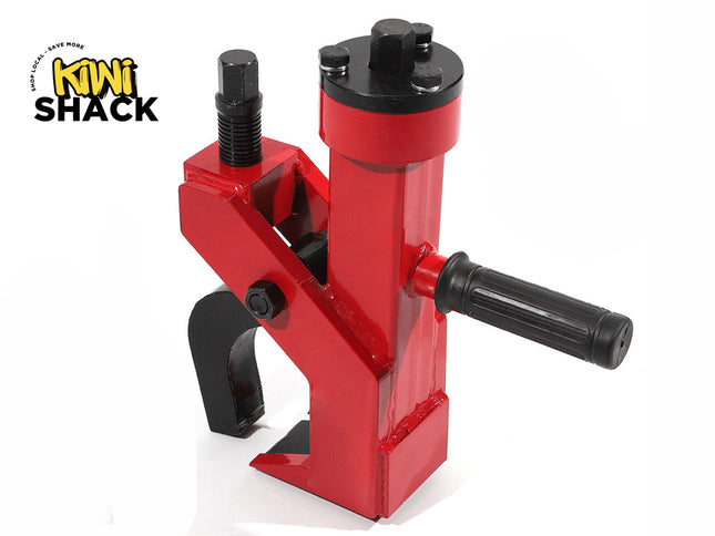 A red and black heavy-duty manual bead breaker tool with a gripping jaw, adjustable bolt, and a side handle, featuring a "Kiwi Shack" logo in the top left corner.