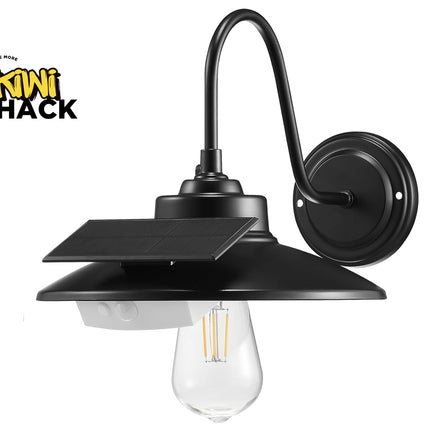 Black solar outdoor wall sconce with a curved gooseneck arm, a flat canopy mount, a small integrated solar panel, and a clear glass bulb, shown on a white background with the Kiwi Shack logo in the top-left corner.